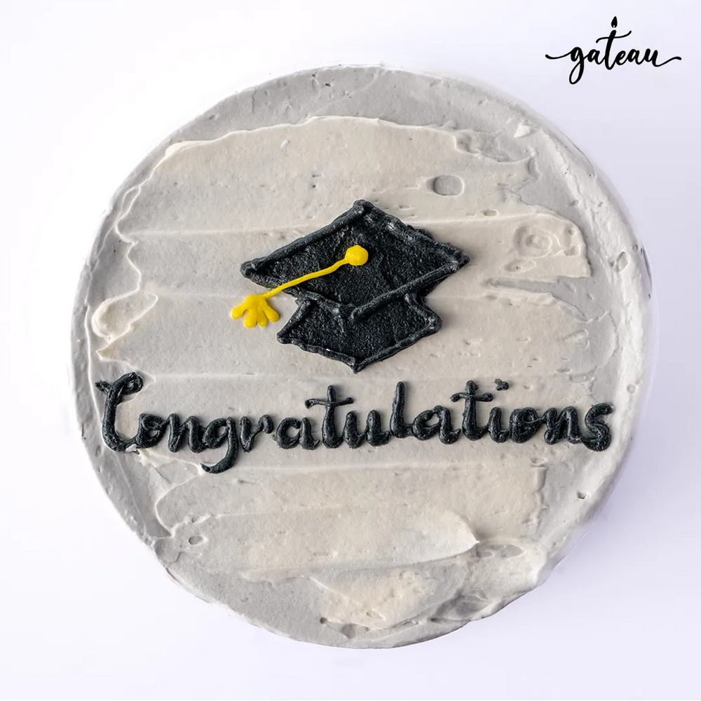 Gateau Gourmet Cafe Graduation Celebration Cake with a black cap and congratulations text on grey frosting