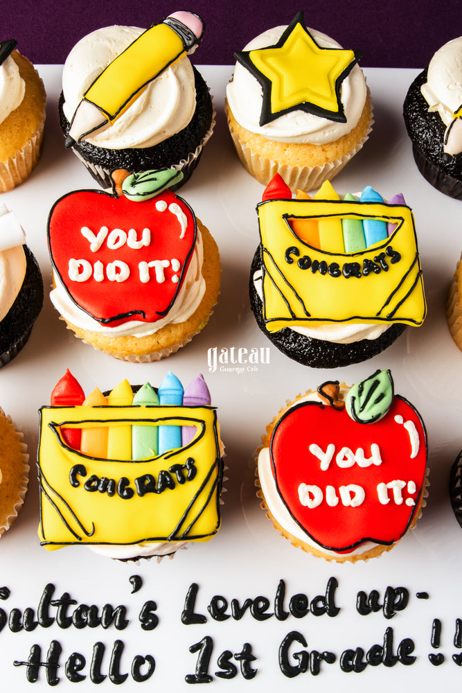 Gateau Gourmet Cafe graduation cupcakes decorated with pencils, stars, apples, and crayons with congratulatory messages