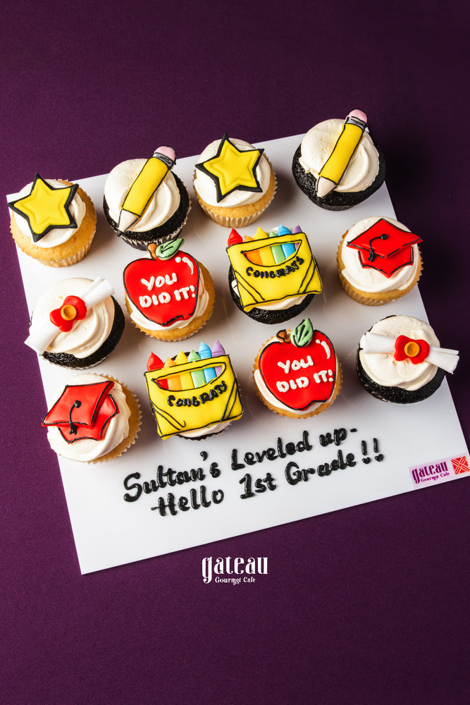 Gateau Gourmet Cafe graduation cupcakes with colorful school-themed frosting and congratulatory messages