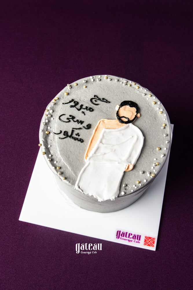 Hajj celebration cake by Gateau Gourmet Cafe with gray frosting and man in white Ihram robe decoration
