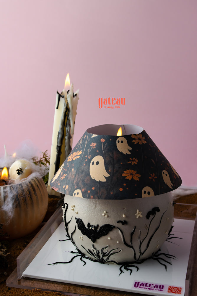 Unique Halloween cake with candle arrangement featuring ghost and bat designs for festive celebrations
