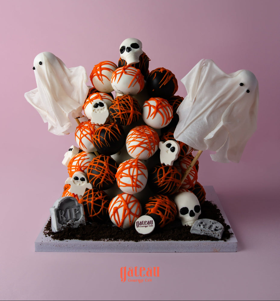 Halloween truffle tower featuring spooky ghost decorations and chocolate truffles in black and orange