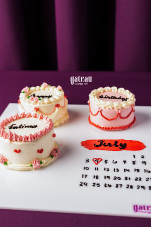 Handcrafted birthday cake for celebration with white frosting and pink decorations from Gateau Gourmet Cafe