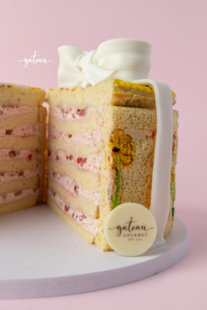 Slice of handcrafted gourmet cake with layered cream and floral decorations by Gateau Gourmet Cafe