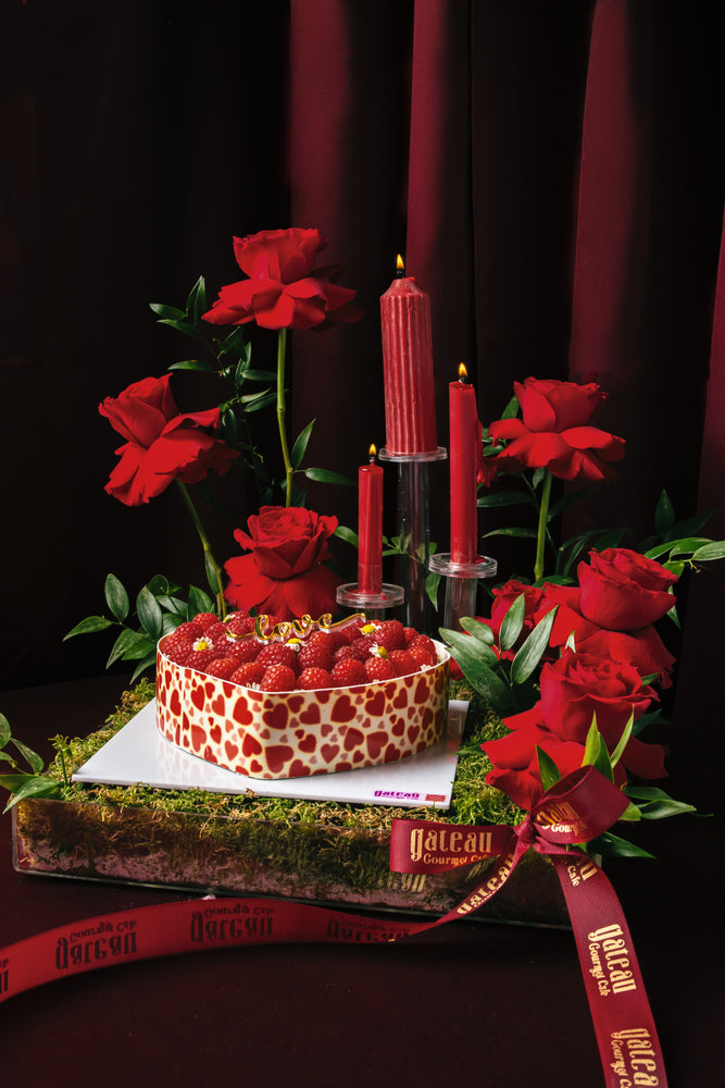 Heart shape raspberry tart from Gateau Gourmet Cafe decorated with fresh raspberries and surrounded by red roses and candles