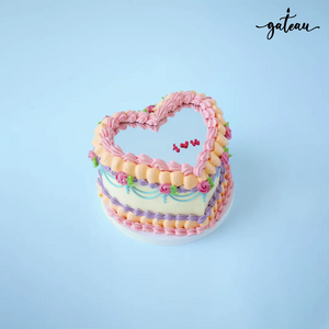 Gateau Gourmet Cafe heart shaped mirror cake with pink and purple frosting and floral decorations