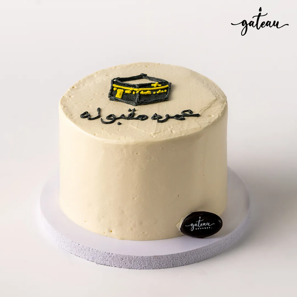 Simple beige Kaaba themed cake with black and yellow decoration on top by Gateau Gourmet Cafe