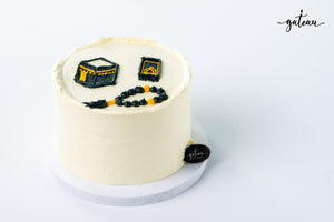 Gateau Gourmet Cafe Kaaba themed cake with white frosting and edible decorations of Kaaba and prayer beads