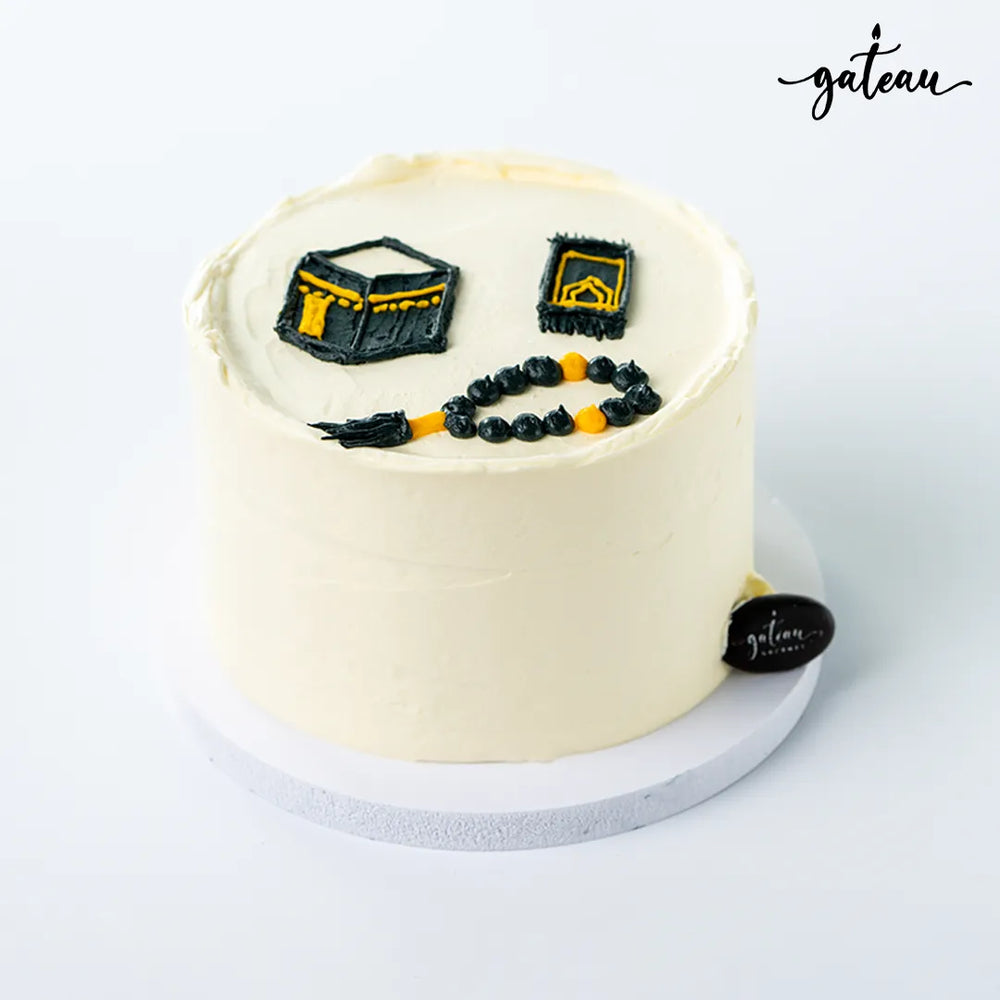 Gateau Gourmet Cafe Kaaba themed cake with black and yellow decorations on white frosting