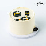 Gateau Gourmet Cafe Kaaba themed cake with black and yellow decorations on white frosting