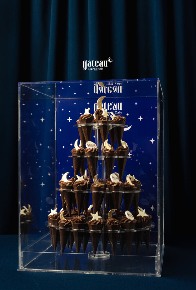 Kunafa Pistachio Chocolate Tower displayed elegantly at Gateau Gourmet Cafe in a clear acrylic case