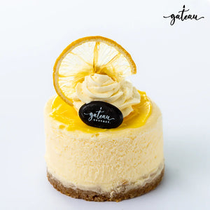 Gateau Gourmet Cafe lemon cheesecake dessert with whipped cream, lemon slice, and smooth yellow topping