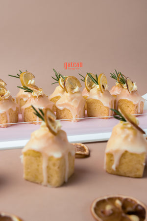 Lemon cream bite treats from Gateau Gourmet Cafe topped with candied lemon slices and fresh rosemary