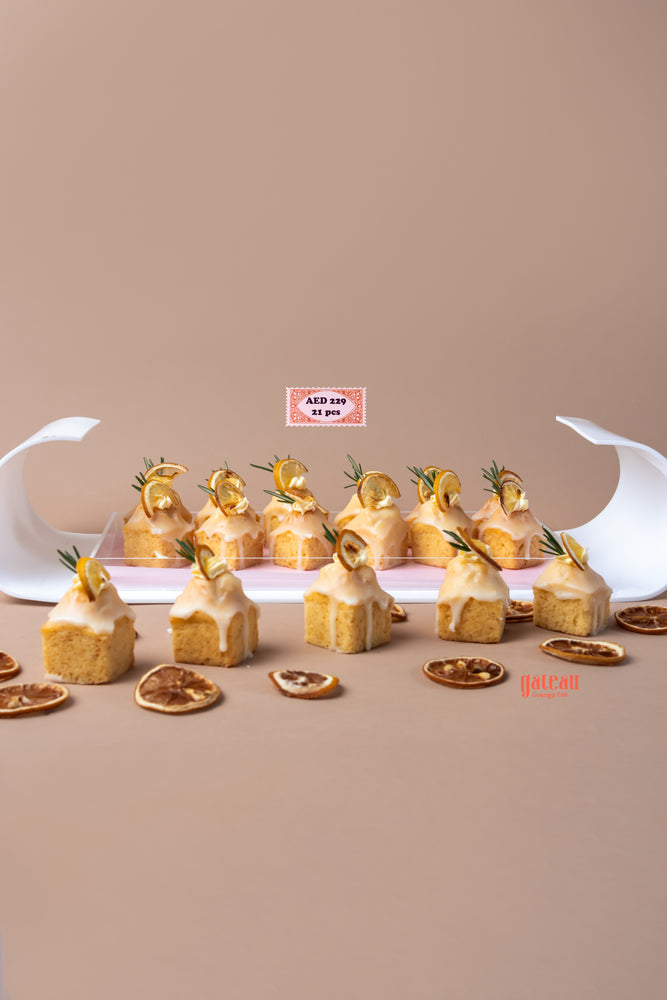 Lemon cream bite treats arranged on a tray with decorative lemon slices and rosemary sprigs