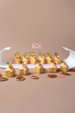 Lemon cream bite treats arranged on a tray with decorative lemon slices and rosemary sprigs