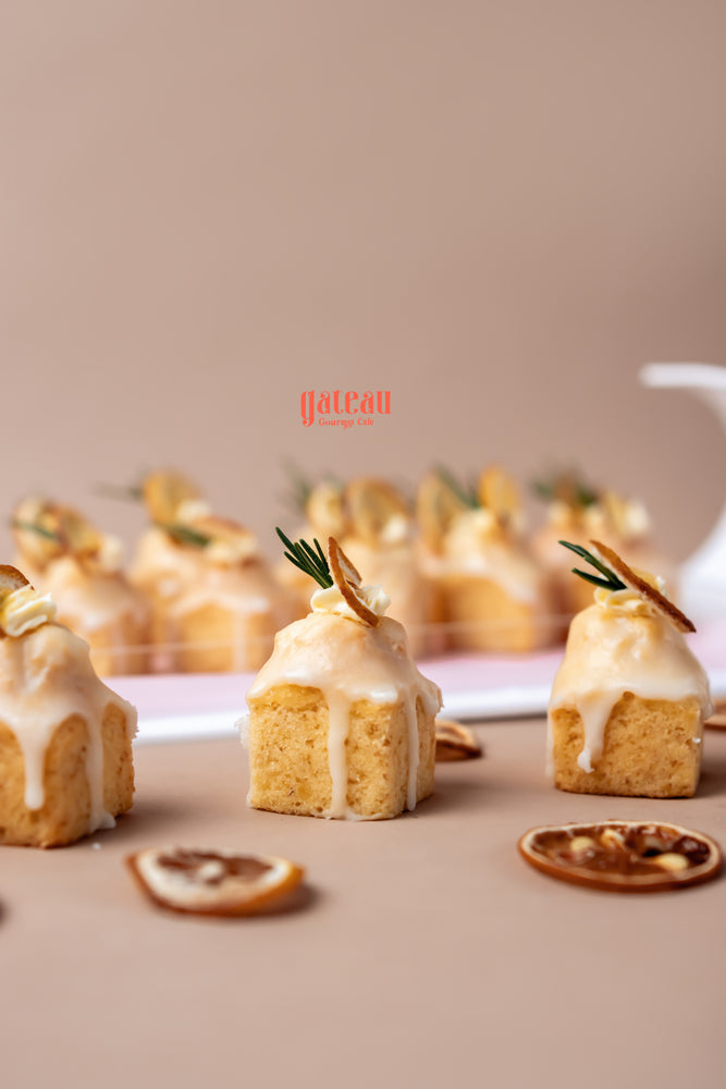Delicious lemon cream bite treats from Gateau Gourmet Cafe with a creamy glaze and garnished with citrus slices