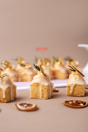 Delicious lemon cream bite treats from Gateau Gourmet Cafe with a creamy glaze and garnished with citrus slices