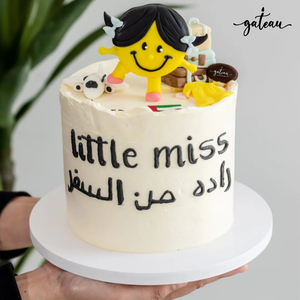 Little miss buttercream cake topper on white frosted cake with Arabic writing and playful design