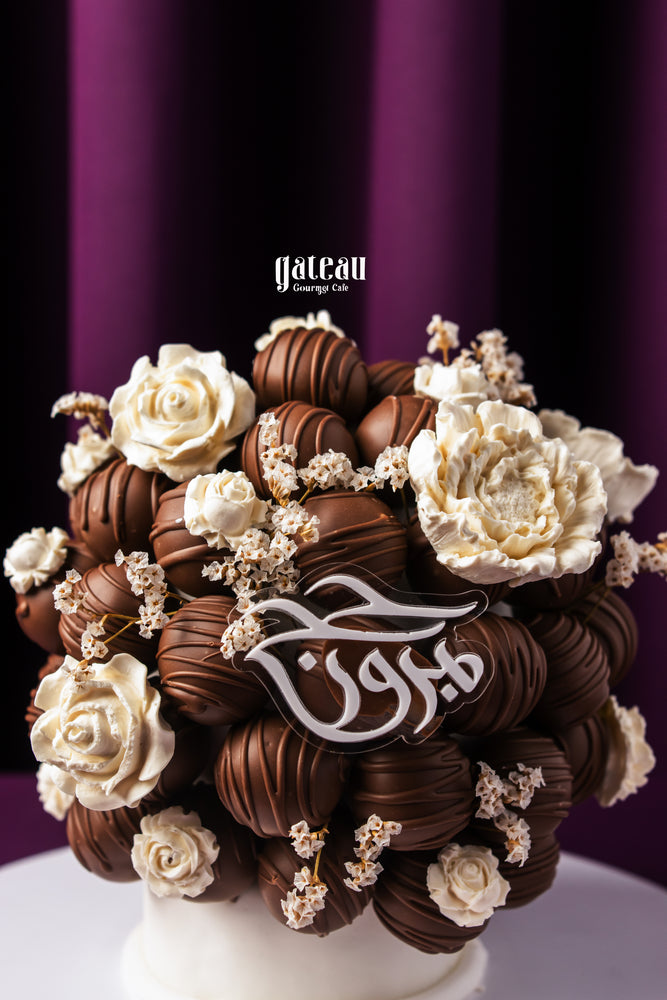 Luxury chocolate truffle cake by Gateau Gourmet Cafe decorated with white chocolate flowers