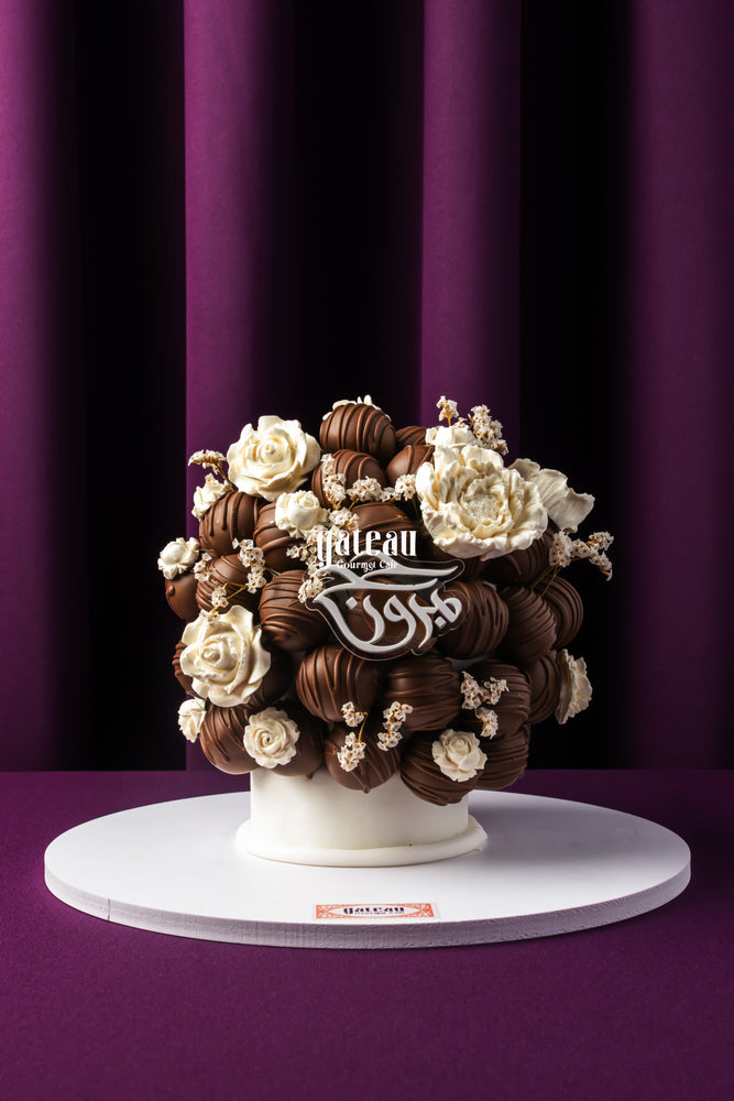 Luxury chocolate truffle cake by Gateau Gourmet Cafe decorated with white chocolate flowers and truffles