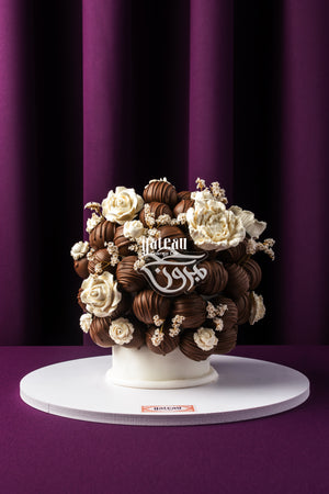 Luxury chocolate truffle cake by Gateau Gourmet Cafe decorated with white chocolate flowers and truffles