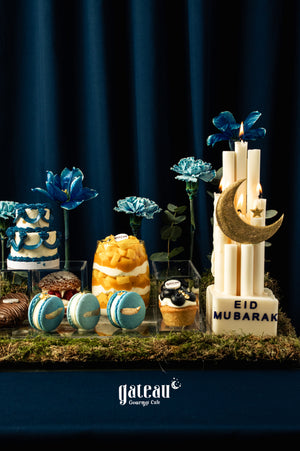 Gorgeous mini sweet dessert tray for Eid featuring colorful cakes, macarons, and decorative flowers