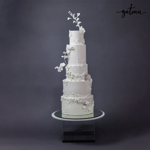 Gateau Gourmet Cafe minimalist wedding cake with six white tiers and delicate floral decorations