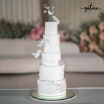Minimalist wedding cake by Gateau Gourmet Cafe featuring five tiers with delicate white floral decorations