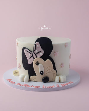 Minnie Mouse cake design with pink bow and decorative stars for birthday celebrations