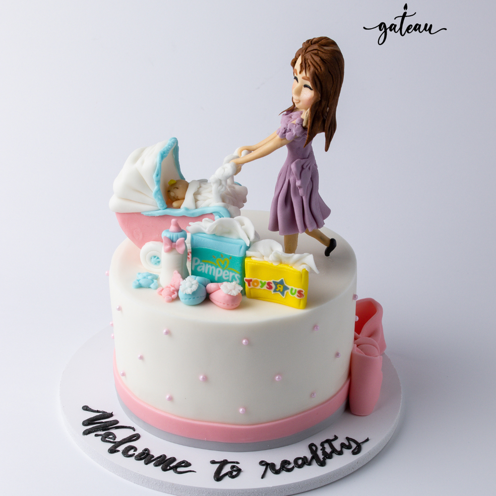 Mommy-and-baby-day-out-cake featuring a figurine of a mother with a baby stroller and playful decorations