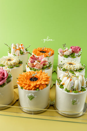 Gateau Gourmet Cafe mini cakes featuring vibrant and detailed mono floral cake designs on white frosting