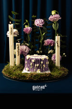 Purple floral cake surrounded by candles and flowers for Mother's Day cake delivery by Gateau Gourmet Cafe
