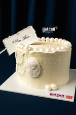 Elegant white Mother's Day cake delivery from Gateau Gourmet Cafe decorated with pearls and a Love Mom tag