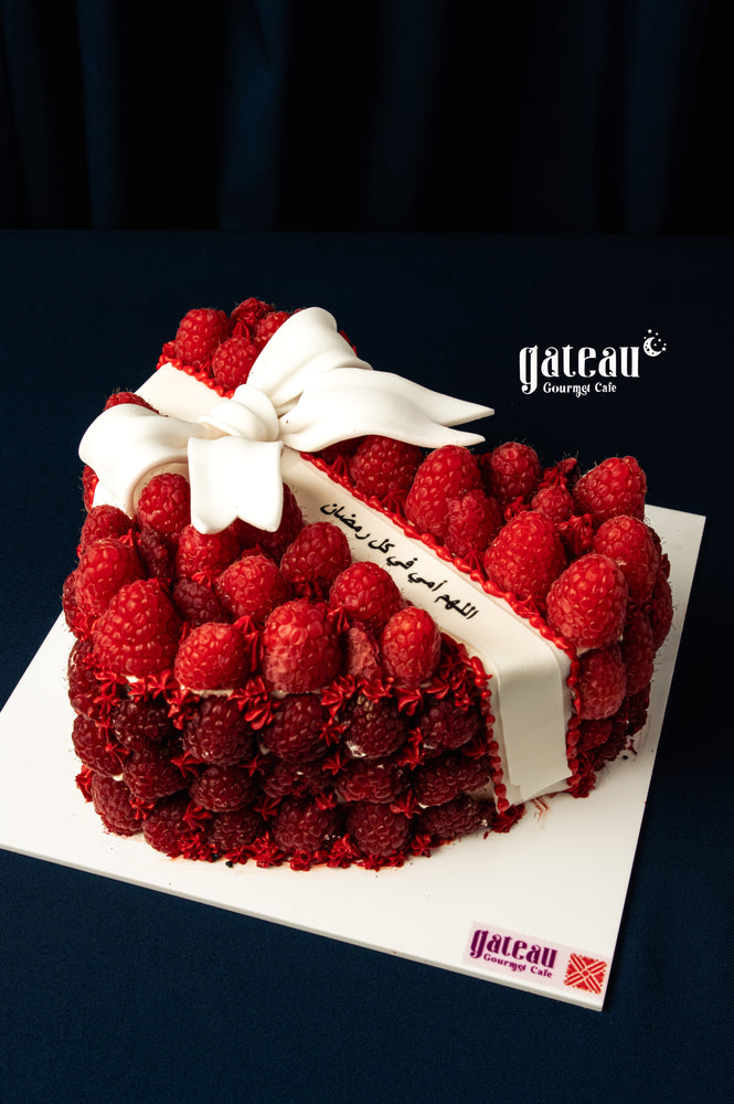 Mother's Day heart cake by Gateau Gourmet Cafe decorated with fresh raspberries and a white fondant bow