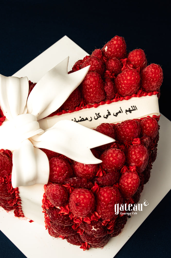 Mother's Day heart cake by Gateau Gourmet Cafe decorated with fresh raspberries and white fondant bow