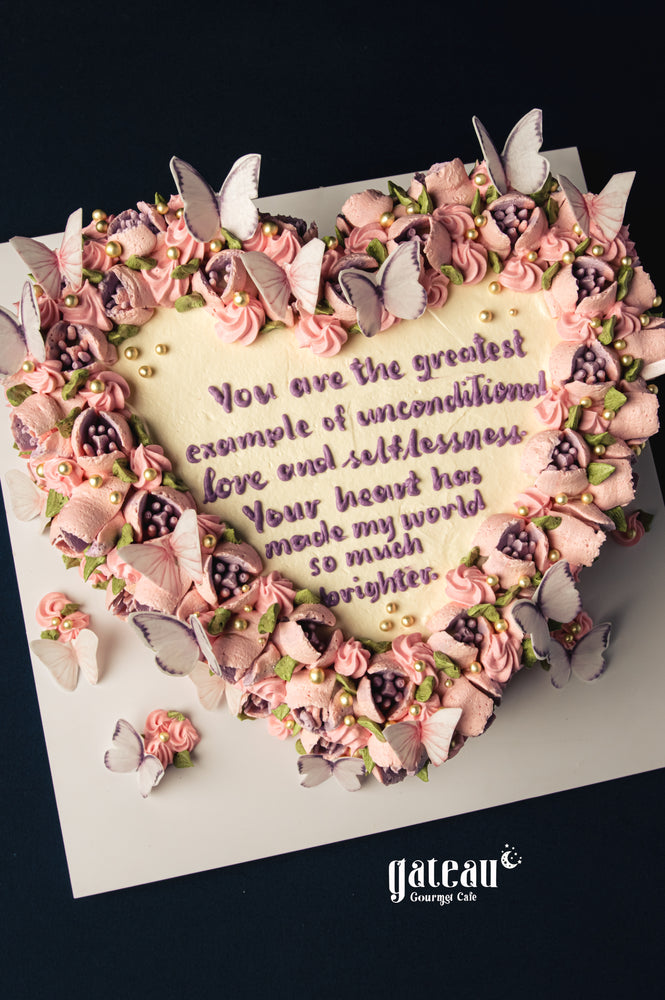 Mother's Day heart-shaped cake with pink frosting, edible butterflies, and heartfelt message from Gateau Gourmet Cafe