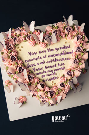 Mother's Day heart-shaped cake with pink frosting, edible butterflies, and heartfelt message from Gateau Gourmet Cafe