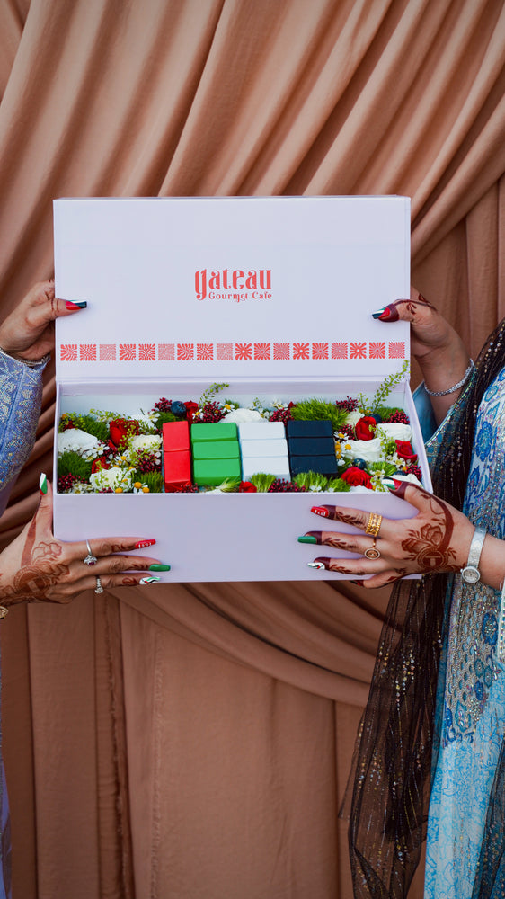 Festive National Day flower box with chocolates from Gateau Gourmet Cafe displayed by two people