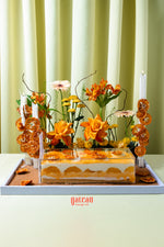 Gateau Gourmet Cafe orange citrus celebration cake decorated with fresh orange flowers and dried citrus slices