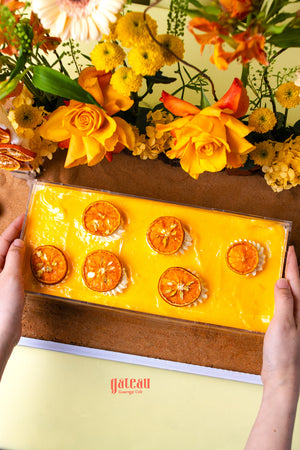Orange citrus celebration cake from Gateau Gourmet Cafe topped with dried orange slices and vibrant yellow frosting