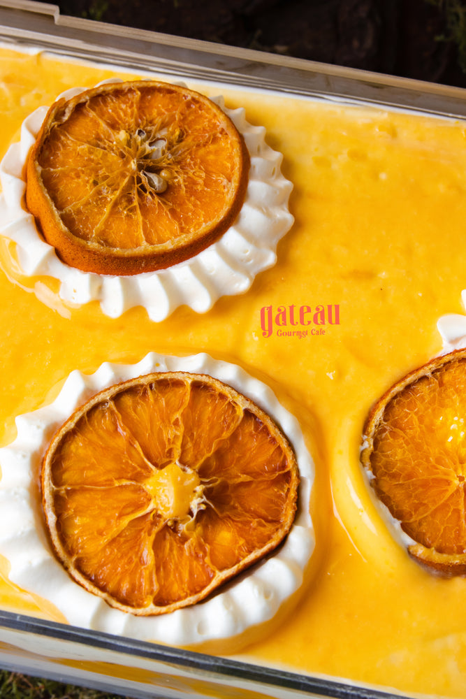 Orange flavored dessert for summer cake with dried orange slices and creamy topping from Gateau Gourmet Cafe