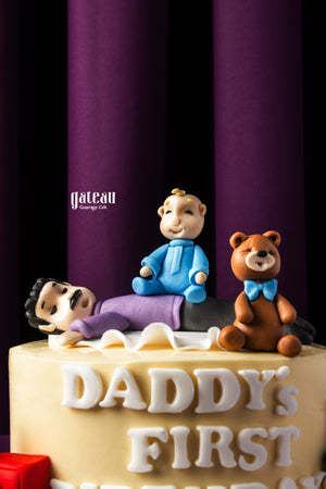 Personalized birthday cake delivery by Gateau Gourmet Cafe featuring a cake with fondant figures and Daddy’s First Birthday text
