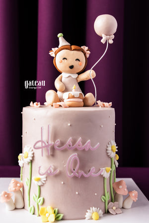 Personalized cakes for birthdays by Gateau Gourmet Cafe featuring a pink cake with a cute baby figure and balloon decoration