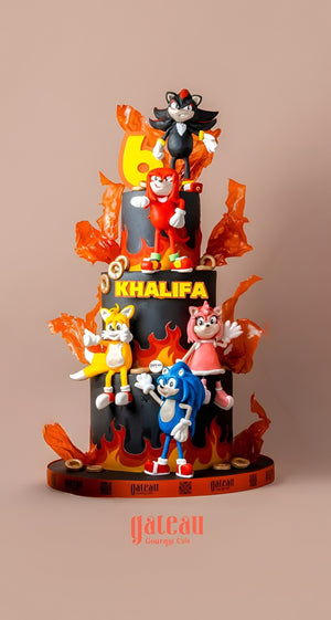 Three-tiered cake with personalized fondant cake designs featuring colorful cartoon characters and fiery decoration