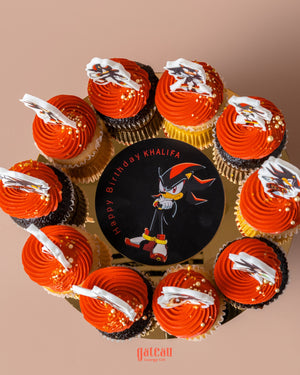 Personalized fondant cake designs featuring a birthday cake with Sonic character and matching cupcakes with orange frosting