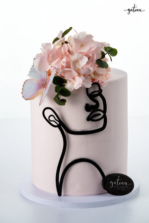 Elegant pink cake with floral decorations and a modern black silhouette of a pink-woman-in-silhouette