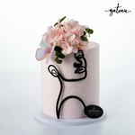 Pink cake featuring a woman's silhouette and floral decoration from Gateau Gourmet Cafe