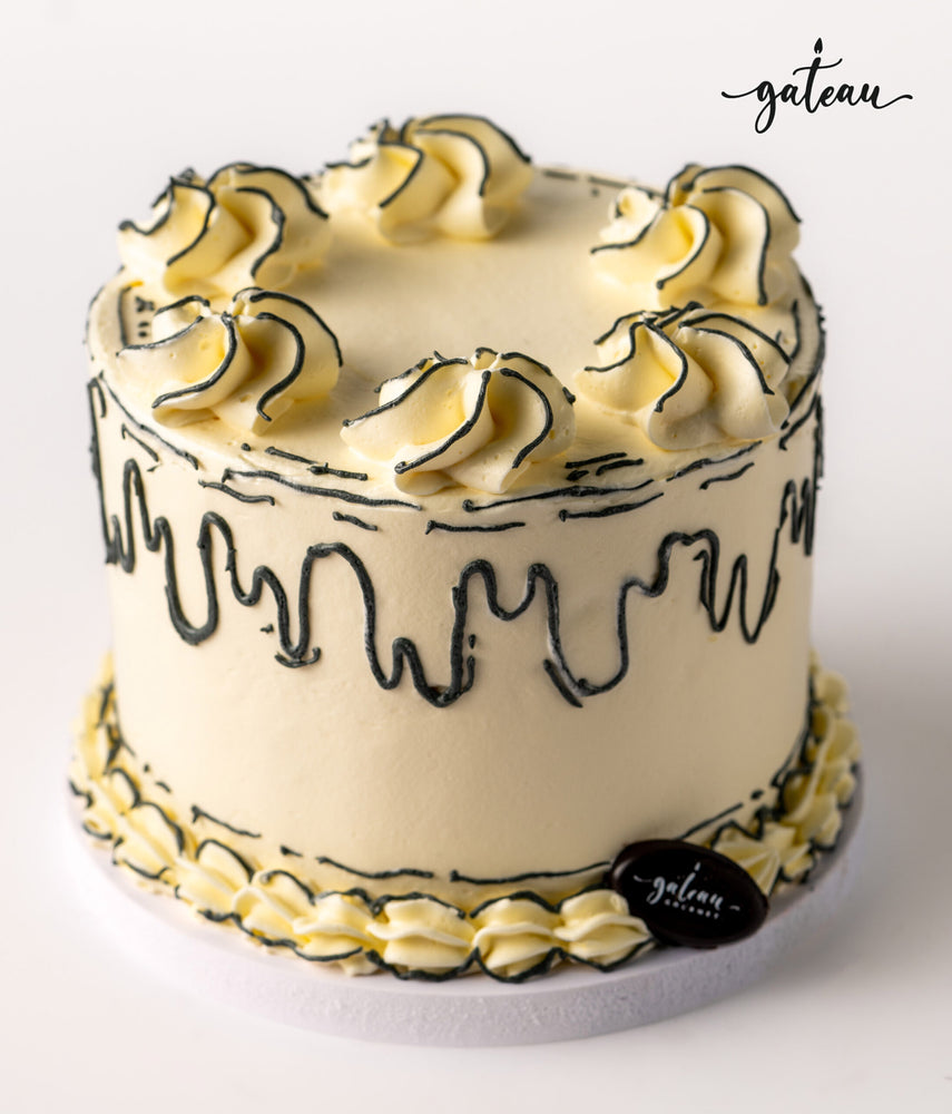 Delicious plain celebration cake with elegant black icing and decorative whipped cream swirls