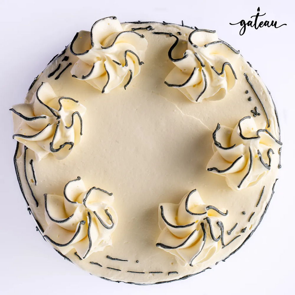 Plain celebration cake with elegant cream decorations and a smooth finish from Gateau Gourmet Cafe