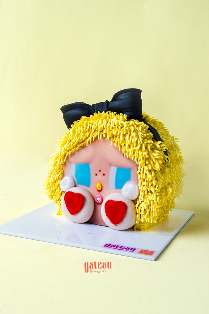Gateau Gourmet Cafe Powerpuff Girls themed cake with yellow frosting hair and black bow decoration